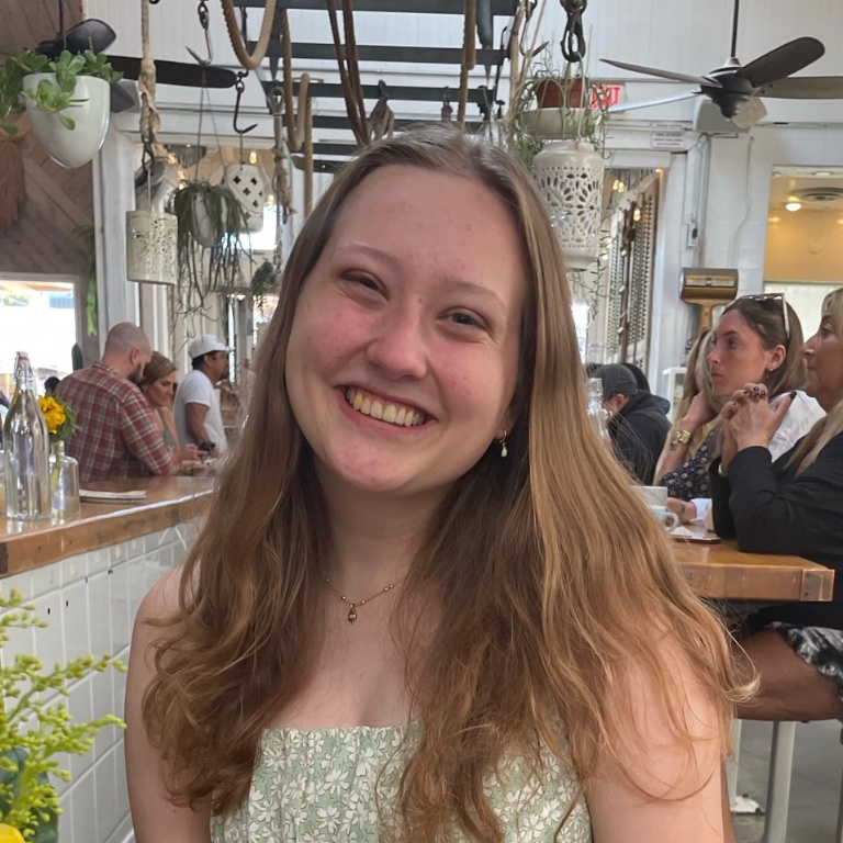 Abby Day smiles for a photo in a busy restaurant